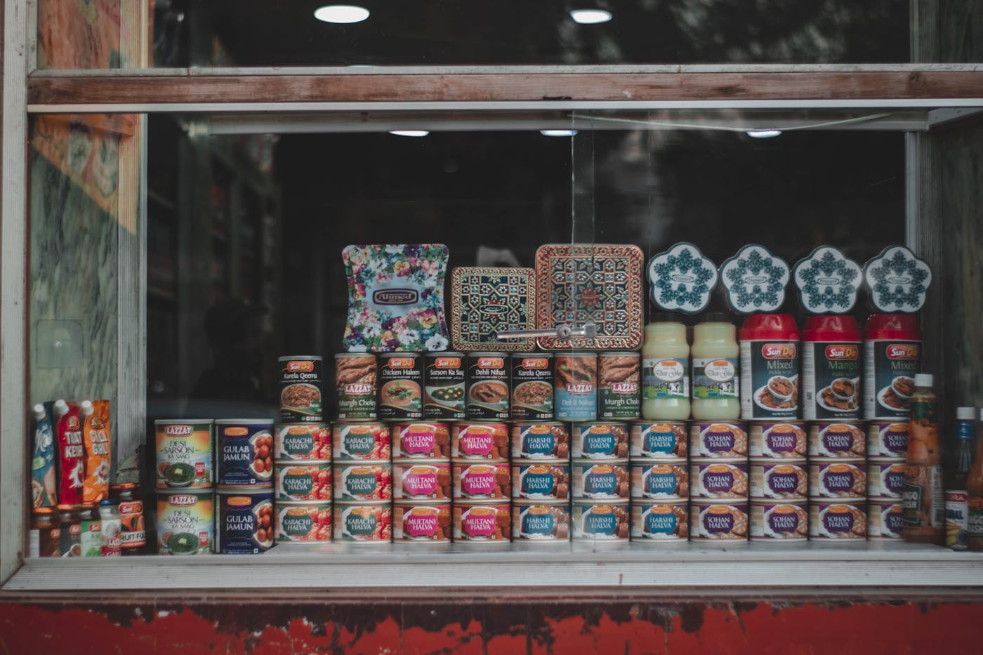 Colourful packaged foods and tins displayed in a shop window — retail, brands, and household purchasing.