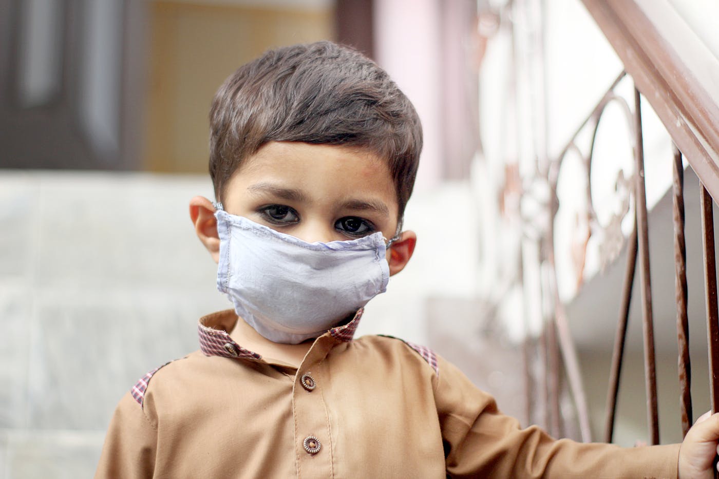 Child wearing a protective face mask — health protection and community hygiene messaging.