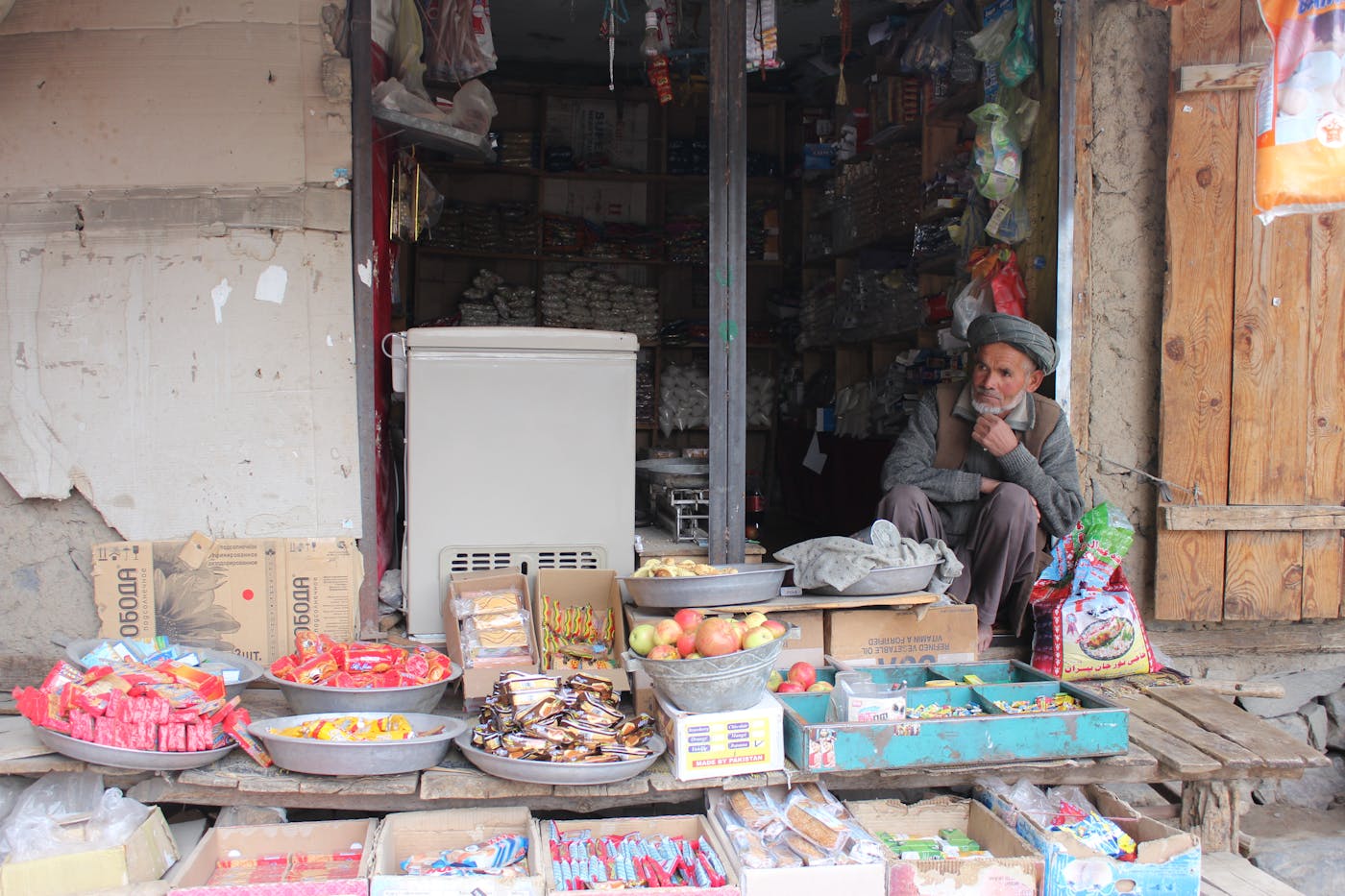 Shopkeeper in a small neighbourhood store with grains, snacks, and daily goods — local trade and livelihoods.